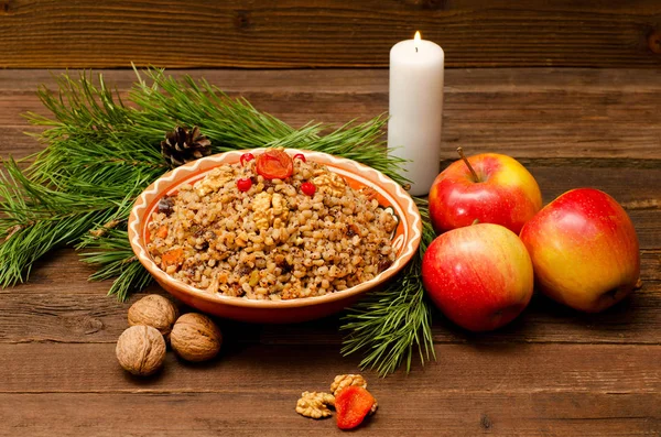 Grâul fiert - un tratament tradițional de Crăciun al slavilor în ajunul Crăciunului kutia. Ramură de blană, măr, lumânare pe un fundal din lemn . — Fotografie, imagine de stoc