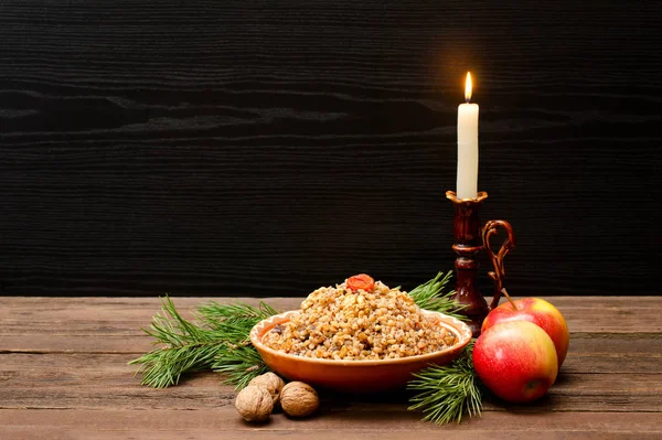 Crăciunul tradițional în Ajunul Crăciunului Slavii kutia pe un fundal negru. Ramură de blană, măr, lumânare pe un fundal din lemn. Spațiu pentru text — Fotografie, imagine de stoc