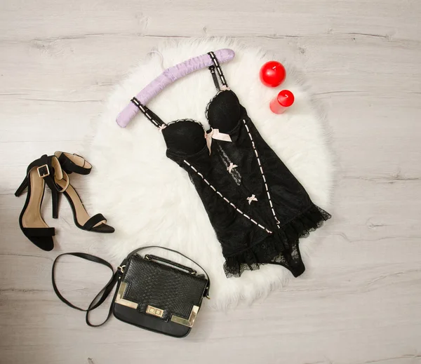 Corsé de encaje negro, zapatos, bolso y velas rojas sobre una piel blanca. Concepto de moda, vista superior —  Fotos de Stock