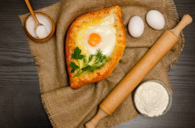 Khachapuri yas, un, yumurta ve tuz siyah tablo üzerinde yumurta ile