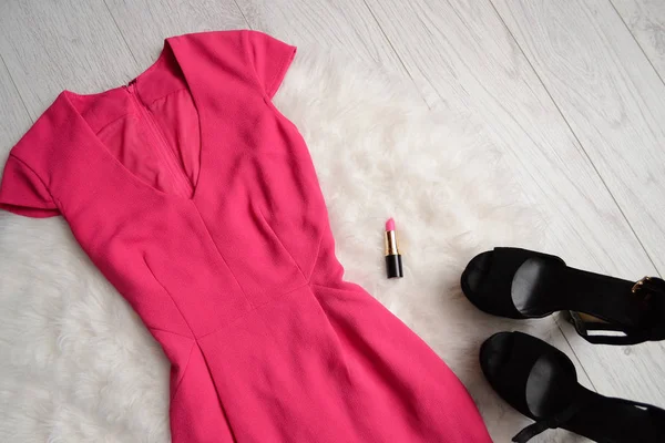 Fashion concept. Helder roze jurk, lippenstift en zwarte schoenen met witte vacht. bovenaanzicht — Stockfoto