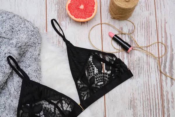 Fashion concept. Black lace bra, lipstick, sweater and grapefruit. On the wooden background, top view. — Stock Photo, Image