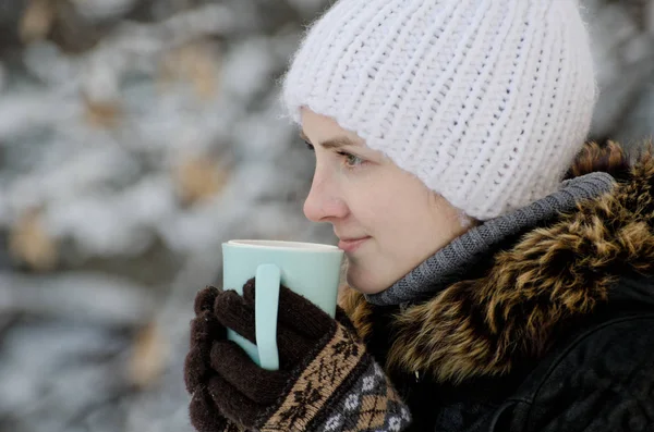 Dziewczyna w zimowe ubrania przy filiżance herbaty, widok z boku, zbliżenie — Zdjęcie stockowe