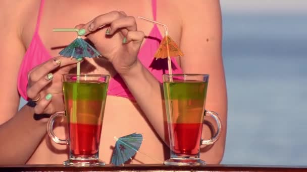 Kız mayo barda kokteyller ile denizin içinde belgili tanımlık geçmiş süslüdür — Stok video