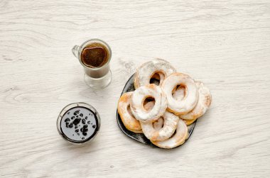 Pudra şekeri, taze kahve ve hafif ahşap fone reçel Donuts serpilir.