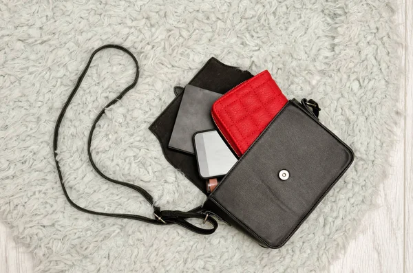 Açık siyah çanta, kırmızı çanta, cep telefonu ve bu rujla. Gri Kürk arka plan, üstten görünüm. moda kavramı — Stok fotoğraf