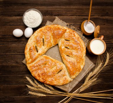 Pasta Sivas'tan üzerinde ahşap arka plan. Pişirme malzemeleri: un, yumurta, tuz ve süt, bir fincan kulaklar. Yukarıdan görüntülemek