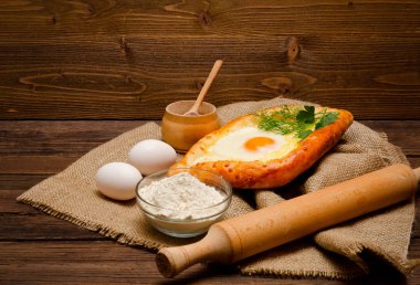 Khachapuri yas, tuz, un, yumurta ve maydanoz üzerinde ahşap masa üzerinde yumurta ile yan görünüm