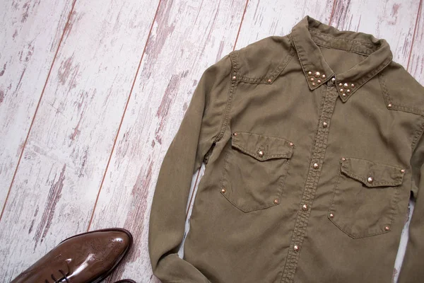 Khaki-färgade skjorta med nitar, lackerad skor. Trä bakgrund, utrymme för text. Fashion-konceptet. ovanifrån — Stockfoto