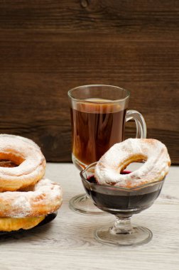 Krema şeker ile çörek, bir bardak çay ve Frenk üzümü jam ahşap bir arka plan üzerinde