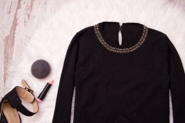 Siyah kazak boncuk beyaz kürk, ruj, toz ile. Moda kavramı, üstten görünüm