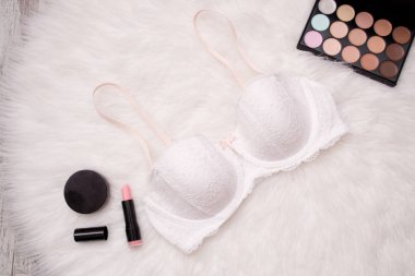 Moda kavramı. Beyaz dantel büstiyer beyaz kürk, ruj, toz, göz farı. Yukarıdan görüntüleyin. Yakın çekim