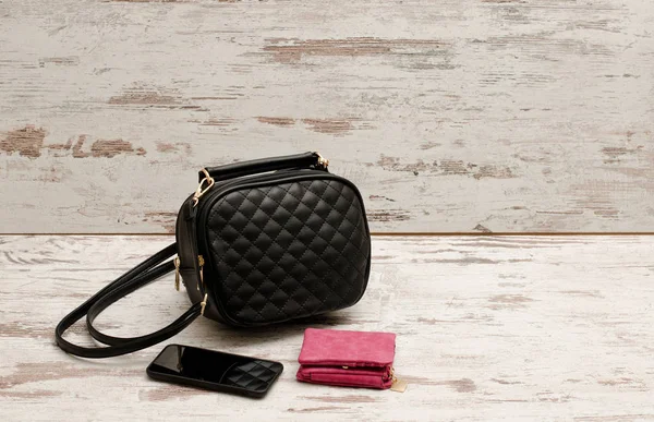 Küçük siyah kadın çanta, çanta ve telefon. Moda kavramı — Stok fotoğraf