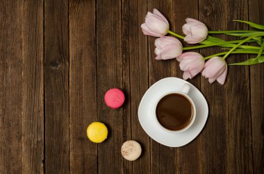 Bir fincan kahve, macarons ve Pembe Lale ahşap arka plan üzerinde. Üstten Görünüm