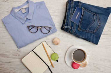 Yolculuk için hazırlık. Mavi gömlek, kot bir pasaport, defter ve kahve. Moda kavramı. Üstten Görünüm
