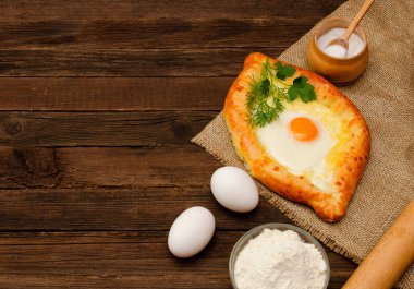 Kırmızı hamur oyulmuş bir kalp. Yumurta ve un siyah bir tabloda, oklava. Üstten Görünüm