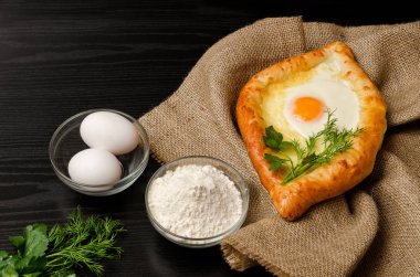 Gürcü mutfağı. Khachapuri yas, un, yumurta ve siyah tablo, closeup maydanoz üzerinde