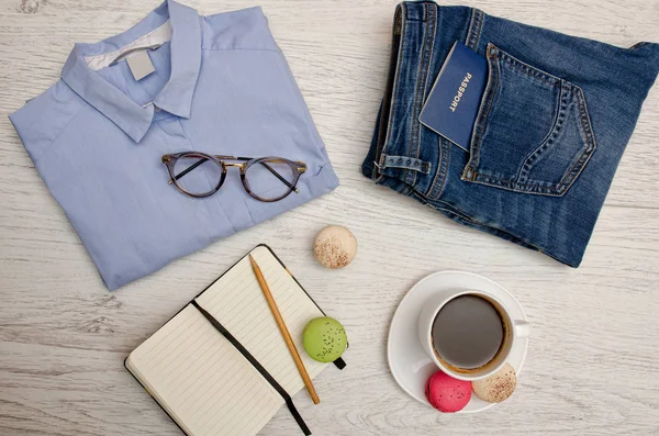 Vorbereitung auf die Reise. blaues Hemd, Jeans mit Pass, Notizbuch und Tasse Kaffee. Modekonzept. Ansicht von oben — Stockfoto