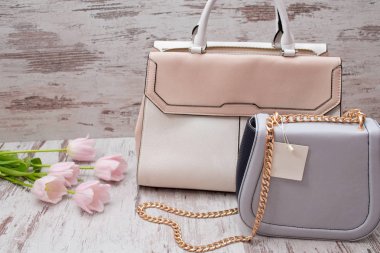Bej ve gri torbaları üzerinde bir ahşap arka plan, Pembe Lale. Moda kavramı.