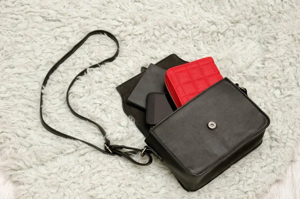 Açık siyah çanta ile şeyler, cep telefonu, kırmızı çanta. Gri arka plan üzerinde kürk. Moda kavramı — Stok fotoğraf