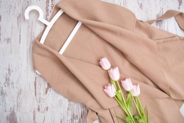 Bir kemer, Pembe Laleler, beyaz trempel ile bej bir palto. Moda kavramı. Yukarıdan görüntülemek