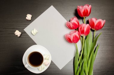 Boş bir sayfa, bir fincan kahve ve marshmallow, siyah ahşap arka plan üzerinde Pembe Lale. Üstten Görünüm, metin için yer