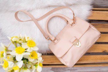 Beyaz kürk, nergis bir buket bej kadın çantası. Moda kavramı, üstten görünüm