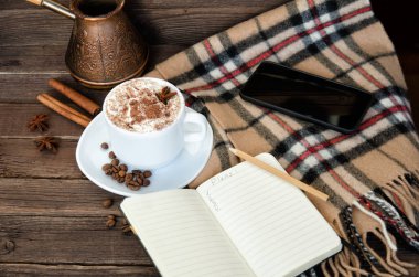 Rahat tatil. Kahve kupa, defter, kalem, akıllı telefon, ekose ve cezve