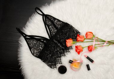 Siyah dantel üst beyaz kürk ve turuncu gül ve kozmetik bir buket. Moda kavramı. Üstten Görünüm