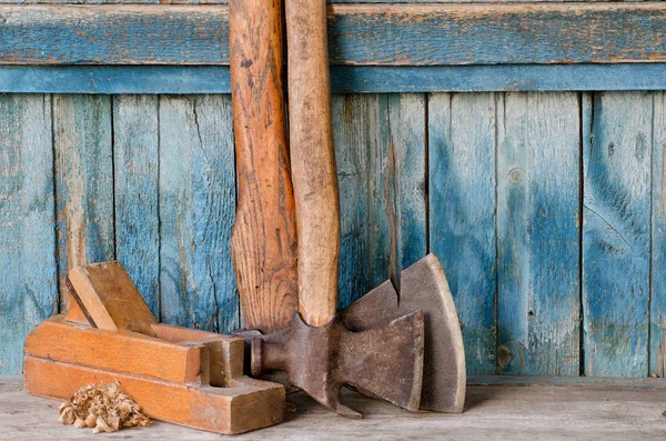 Axes plus anciens, plan et copeaux sur un fond en bois bleu, avec espace pour le texte — Photo