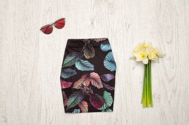 Siyah etek ananas, gözlük ve Nergis bir buket. Moda kavramı. Ahşap arka plan.