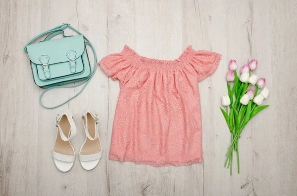 Pembe bluz, beyaz ayakkabı, çanta ve Lale bir buket. Moda kavramı. Ahşap arka plan.