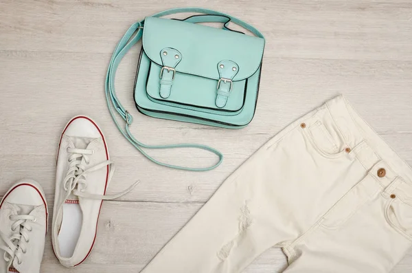 Белые джинсы и кроссовки, мятная сумка. Модная концепция. Деревянный фон . — стоковое фото