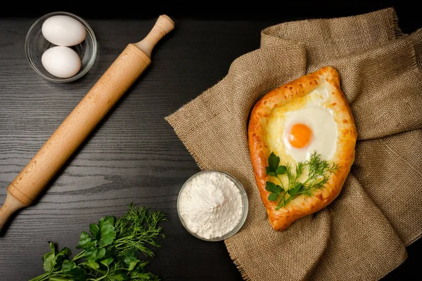 Gürcü mutfağı. Khachapuri en iyi görünümünü tutuyordu, un, yumurta ve oklava. Siyah tablo, metin için yer