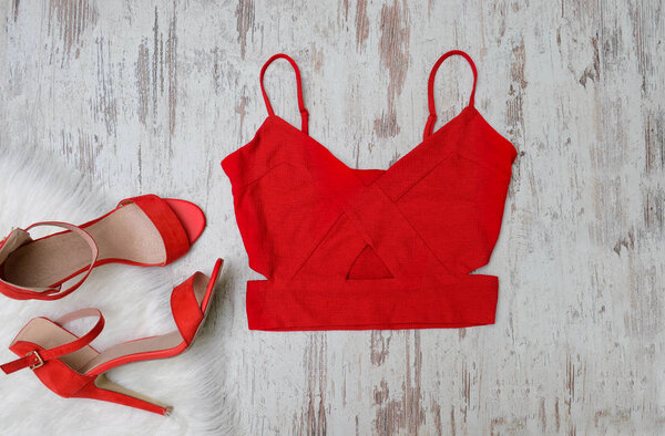 Fashion concept, female wardrobe. Red top and shoes on a light background. Top view
