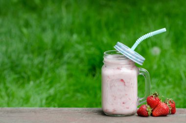 Yoğurt ve çilek yeşil çimen, metin için yer bir arka plan üzerine bir fincan