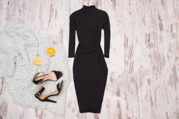 Чорна сукня з рукавом, взуттям і половинками апельсина на дерев'яному фоні. Модна концепція, вид зверху — стокове фото