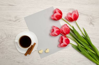 Boş bir kağıt, bir fincan kahve ve marshmallow, üzerine Pembe Lale ahşap arka plan ışık. Üstten Görünüm, metin için yer