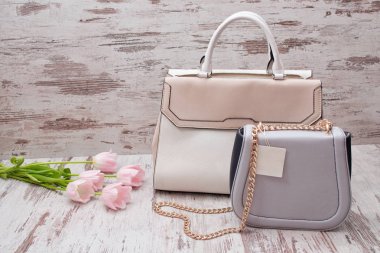 Bej ve gri torbaları üzerinde bir ahşap arka plan, Pembe Lale. Moda kavramı.