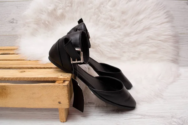Sapatos pretos numa palete, pele branca. Conceito na moda — Fotografia de Stock
