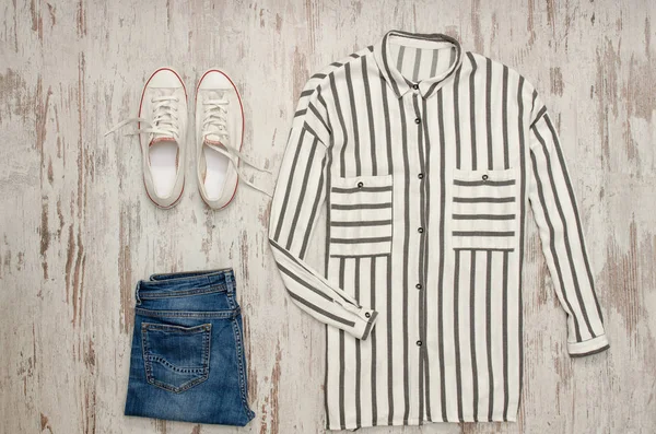 White striped shirt, white sneakers and jeans. Fashionable concept