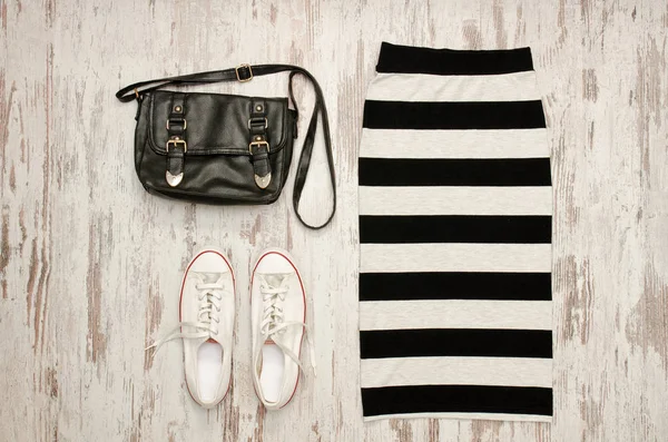 Çizgili etek, siyah çanta ve beyaz spor ayakkabı. Moda kavramı