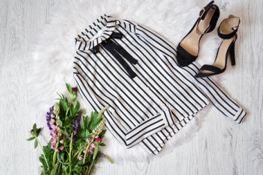 Beyaz bluz ve siyah ayakkabılar beyaz kürk, bir buket çiçek üzerinde çizgili. Moda kavramı