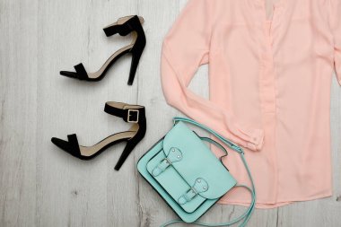 Şeftali bluz, siyah ayakkabılar, el çantası. Moda kavramı. Ahşap arka plan