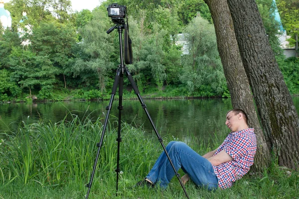 Fotograf je v režimu spánku při střelbě na pozadí řeky — Stock fotografie
