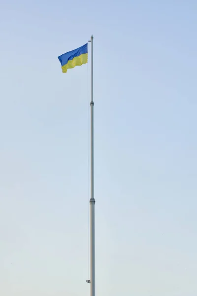 Bandera de Ucrania en asta de bandera contra el cielo azul, marco vertical —  Fotos de Stock