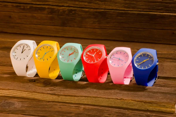 Multi-colored sports watch on a wooden background