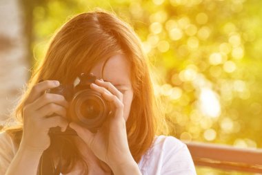 Kız fotoğrafçı yeşil arka planı fotoğraf çeker. Önden Görünüm