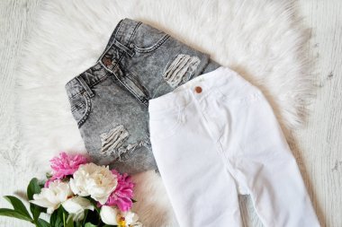 Gri şort, beyaz kot pantolon ve beyaz kürk peonies hizalayıp düzensiz bırakmak. Moda kavramı