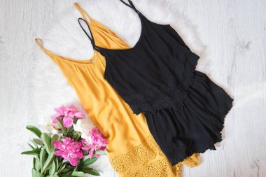 Turuncu ve siyah romper, peonies beyaz kürk üzerinde. Moda kavramı